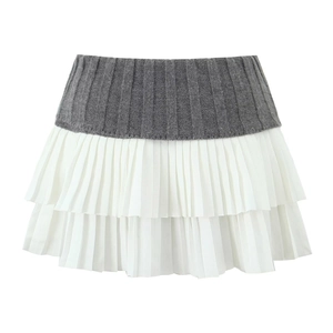 Detail view of the gray ribbed knit waistband and layered white pleated skirt hem