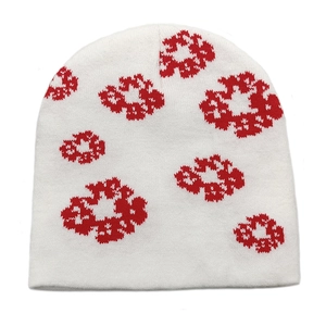 Detailed view of white knit beanie featuring red pixelated floral jacquard patterns