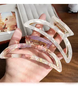 Detailed macro view of acetate hair claws in marble white and purple gold foil patterns