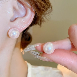 Close-up of elegant 12mm pinkish-white faux pearl stud earrings with metallic luster