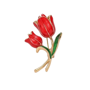 Elegant gold tulip brooch with red enamel flowers and green leaves on white background