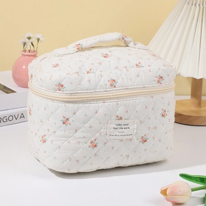 Close-up of quilted floral cotton makeup bag with printed fabric label and handle