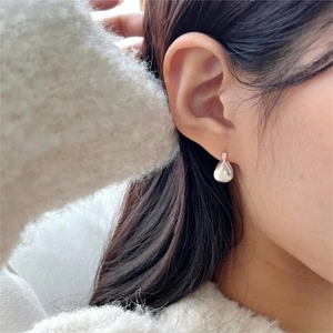 Close-up of polished 925 sterling silver teardrop earrings on a model ear