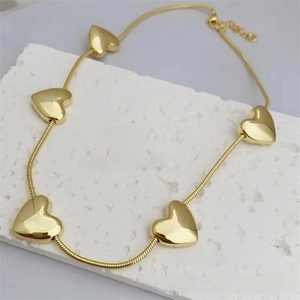 Detail of 18k gold plated copper necklace with five 3D heart charms and snake chain