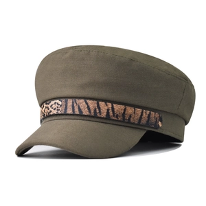 Close-up of olive green newsboy hat featuring decorative leopard print chain band