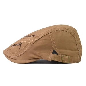 Détail d'une casquette plate camel avec broderie latérale et boucle en métal