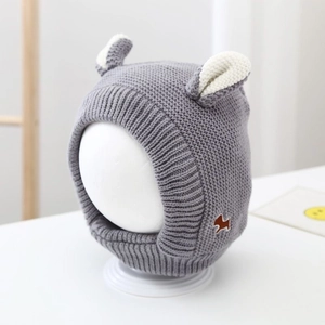 Close-up of grey knit baby winter hat featuring plush white ears and animal patch detail