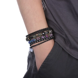 Détail de bracelets multicouches en cuir et corde tressée sur un poignet masculin