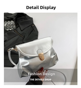 Detailed close-up of a silver soft leather pleated bag with golden metal clasp closure