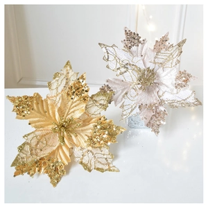 Detail of champagne and gold poinsettia flowers with glitter on white surface