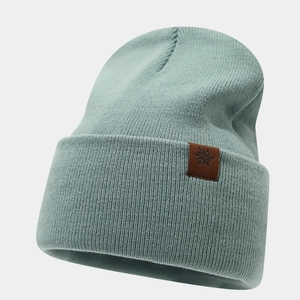 Detail of mint green ribbed knit beanie with brown snowflake leather patch decoration