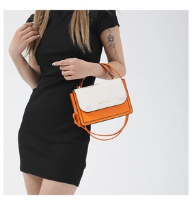 Detail of orange and white leather shoulder bag featuring gold-tone hardware and logo