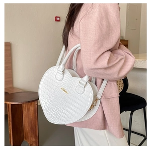 Détails du sac à main cœur blanc en relief crocodile avec des finitions dorées