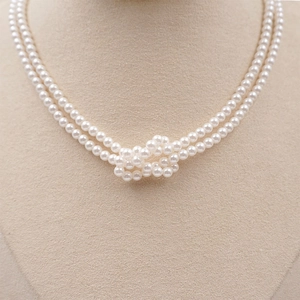 Elegant double-layered white pearl necklace featuring a central knotted design for women