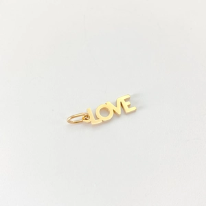 Detailed view of polished 18K gold-plated LOVE pendant with vintage metal finish