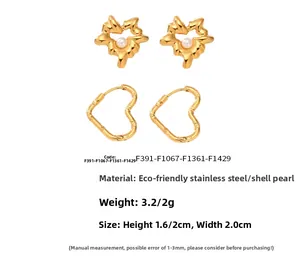 Detail of gold stainless steel heart and star earrings with shell pearls and textures