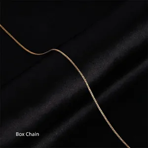 Macro shot of a 18k gold plated stainless steel box chain necklace on black silk