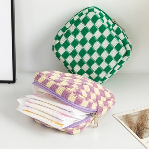 Macro detail of checkered woven cosmetic bags showing dual capacity for personal items