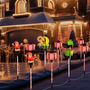 Solar Christmas path lights featuring Santa and gift box designs on lawn at night