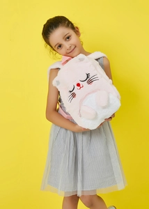 Close-up of plush girl backpack with rabbit embroidery worn by a child on yellow background