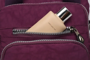Détail de la poche latérale en nylon violet montrant la capacité avec un flacon de soin
