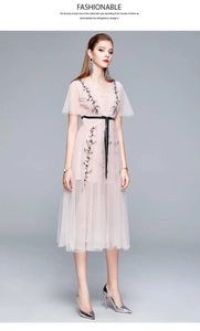 Détail de la robe rose en tulle avec broderie florale et ceinture en ruban noir