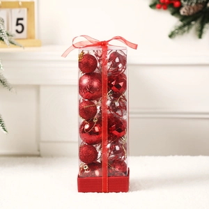 Red Christmas ball ornament set in clear gift box with festive ribbon on fireplace mantel