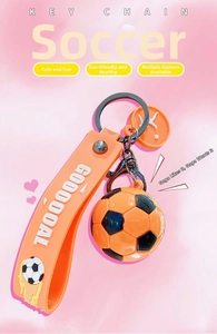 Dettaglio portachiavi calcio con cinturino in silicone arancione e scritta 3D a rilievo