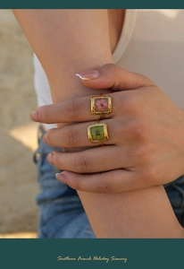 Macro detail of two vintage gold rings with pink and green dried flowers in resin