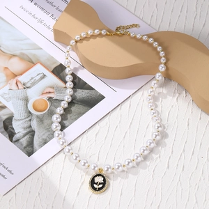 Detail of baroque pearl necklace with floral pendant and sparkling rhinestone border