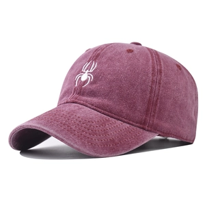 Close-up of white spider embroidery on washed purple cotton vintage baseball cap