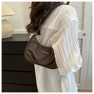 Dettaglio della borsa sottobraccio marrone scuro con texture increspata in PU lucido
