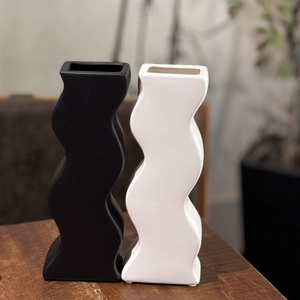 Vista dettagliata di vasi moderni in ceramica opaca con design a S ondulato in bianco e nero