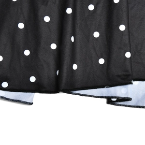 Detailed close-up of black fabric with white polka dots and stitching for backless dress