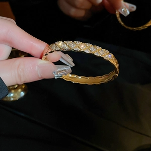 Detailed close-up of a quilted gold-plated bangle with sparkling micro-pave zircon crystals