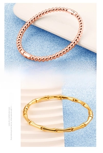 Detailed macro view of polished bamboo-style gold bangle and rose gold bead bracelet