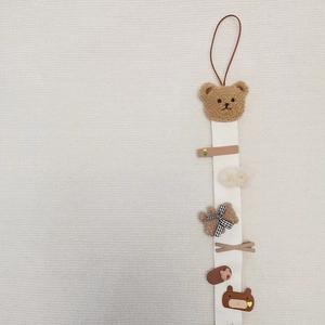 Detail view of bear-themed wall hanging organizer for kids' hair clips and bows
