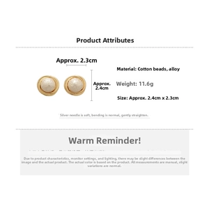 Detail view of round gold earrings with textured cotton pearls and S925 silver needles