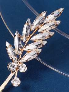Macro shot of gold bridal hair pin featuring marquise cut rhinestones in leaf shapes
