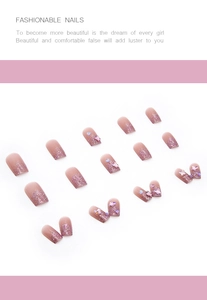 Detail of pink gradient press-on nails with 3D resin butterfly and sparkling glitter