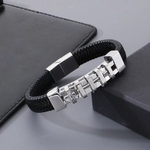Dettaglio di un bracciale in pelle intrecciata nera da uomo con fibbia in acciaio lucido