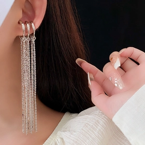 Close-up of silver multi-layer tassel ear cuff with fine chains on a black background