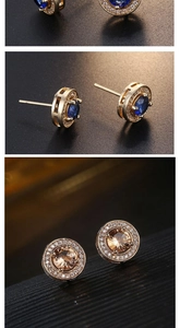 Macro detail of round gold-plated stud earrings with blue and amber stones and zircon pavé