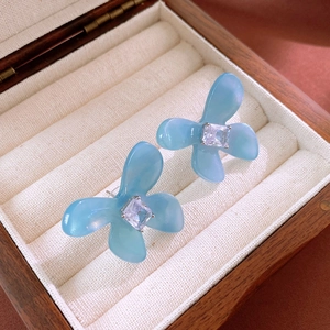 Orecchini a fiore blu chiaro con zircone quadrato in una scatola regalo in legno