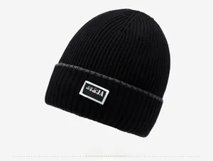Close-up of black ribbed knit beanie featuring an embroidered fashion patch detail