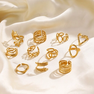 11-piece gold stainless steel ring set with heart and leaf designs on silk fabric