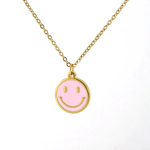 Detailed view of pink enamel smiley face pendant on 18K gold plated stainless steel necklace