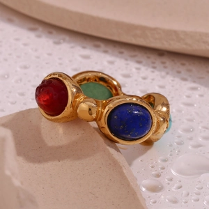 Dettaglio macro di anello placcato oro 18K con pietre preziose rosse, blu e verdi