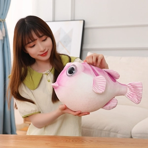 Gros plan d'une peluche fugu rose aux grands yeux dans un salon à l'ambiance chaleureuse