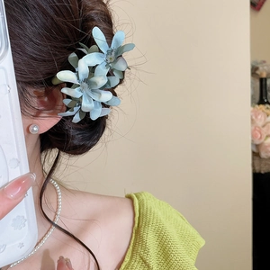 Close-up of light blue fabric flower hair pin with delicate silk petal texture on model